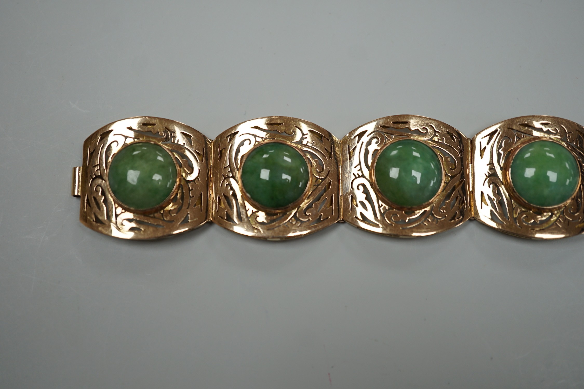 A continental 18k yellow metal and seven stone cabochon jade set bracelet, with pierced links, 18.5cm, gross weight 39.3 grams.